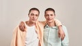 Portrait of two happy caucasian men, young twin brothers hugging and smiling at camera while posing together isolated Royalty Free Stock Photo