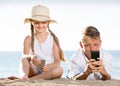 Smiling kids on beach with phone in hands Royalty Free Stock Photo