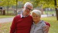 Portrait of two happy elderly adults in the park. Married pensioner couple looking to the camera and smiling. Royalty Free Stock Photo