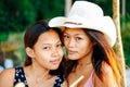 Portrait of two happy female Asian friends on beach