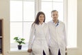Portrait of two male and female doctors standing by the window and smiling looking at camera. Royalty Free Stock Photo