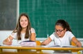 Portrait of two happy schoolgirls in a classroom Royalty Free Stock Photo