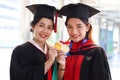 Portrait of two happy smiling graduated students holding  gold medal award, young beautiful Asian women looking at camera so proud Royalty Free Stock Photo