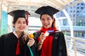 Portrait of two happy smiling graduated students holding  gold medal award, young beautiful Asian women looking at camera so proud Royalty Free Stock Photo