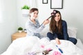 Caucasian woman curling her best friend`s long hair