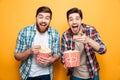 Portrait of a two happy young men eating popcorn Royalty Free Stock Photo