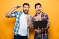 Portrait of a two happy young men holding laptop Royalty Free Stock Photo