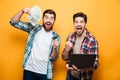 Portrait of a two happy young men holding laptop Royalty Free Stock Photo