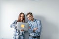 Happy mix-race couple holding laptop computer while standing and celebrating isolated over gray wall background Royalty Free Stock Photo