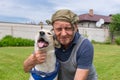 Portrait of two homeless fiends - dirty mature man and cute mixed breed dog that both are happy