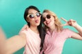 Portrait of two joyful women vin sunglasses isolated on blue Royalty Free Stock Photo