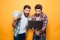 Portrait of a two joyful young men using laptop Royalty Free Stock Photo