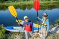 Two kids enjoying kayak ride on beautiful river. Little boy and teenager girl kayaking on hot summer day. Water sport Royalty Free Stock Photo