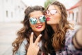 Gorgeous brunette girlfriends with hairstyle, mirrored sunglasses and red lips making selfie with duck face. Royalty Free Stock Photo