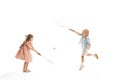 Portrait of two little children, boy and girl playing together in badminton, posing isolated over white studio Royalty Free Stock Photo