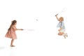 Portrait of two little children, boy and girl playing together in badminton, posing isolated over white studio Royalty Free Stock Photo