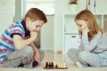 Portrait of two little children concentrated playing chess Royalty Free Stock Photo