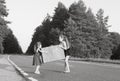 Portrait of two little girls carring at vintage suitcase on the road at sunset. Sisters enjoyed a Holidays over summer nature Royalty Free Stock Photo