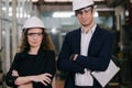 Portrait of Two Machinists is standing with confident with   safety helmet in front the glass wall of industry factory Royalty Free Stock Photo