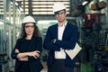 Portrait of Two Machinists is standing with confident with   safety helmet in front the glass wall of industry factory Royalty Free Stock Photo