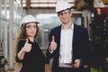 Portrait of Two Machinists is standing with confident with   safety helmet in front the glass wall of industry factory Royalty Free Stock Photo