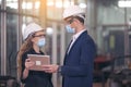 Portrait of Two Machinists is standing with tablet and safety helmet in front the glass wall of industry factory Royalty Free Stock Photo