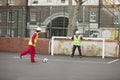 Two manual workers playing football