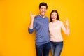 Portrait of two married people rockers enjoy concert show horns symbol grimace show tongue out wear blue pink jumper Royalty Free Stock Photo