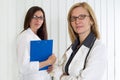 Portrait of Two Middle Age Female Doctors Smiling and Looking at Camera Royalty Free Stock Photo