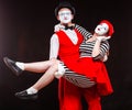 Portrait of two mime artists, isolated on black background. Man holds woman in his arms. Symbol of happy marriage, sweet Royalty Free Stock Photo