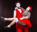 Portrait of two mime artists, isolated on black background. Man holds woman in his arms. Symbol of happy marriage, sweet Royalty Free Stock Photo