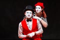 Portrait of two mime artists, isolated on black background. Woman appears from behind a man smiling. Symbol of happy Royalty Free Stock Photo