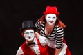 Portrait of two mime artists, isolated on black background. Woman appears from behind a man smiling. Symbol of happy Royalty Free Stock Photo