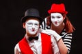 Portrait of two mime artists, isolated on black background. Woman and man look at camera. Symbol of happy marriage Royalty Free Stock Photo