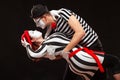 Portrait of two mime artists performing, isolated on black background. Man leaning his woman while dancing. Symbol of Royalty Free Stock Photo