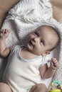 Portrait of two months baby boy looking cheerfully. View from above. Flat lay photo. Emotional expressions