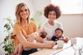 Portrait Of Two Mothers With Babies Meeting Around Table On Play Date At Home Royalty Free Stock Photo