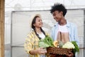 Portrait of two multiethnic teenager friend, Asian girl and African boy hold fresh harvest fruit vegetable basket at front of