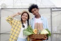 Portrait of two multiethnic teenager friend, Asian girl and African boy holding fresh harvest fruit vegetable basket at front of Royalty Free Stock Photo