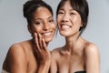 Portrait of two multinational half-naked women hugging and laughing Royalty Free Stock Photo