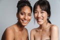 Portrait of two multinational half-naked women hugging and laughing Royalty Free Stock Photo