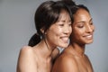 Portrait of two multinational half-naked women hugging and laughing Royalty Free Stock Photo