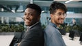 Portrait two multinational male colleagues men African man arab Indian manager posing in office company standing back to Royalty Free Stock Photo