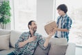 Portrait of two nice attractive cheerful cheery glad guys daddy pre-teen son giving paper box for dad`s day birthday in