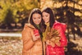 Portrait of two nice attractive pretty cheerful cheery best girlfriends spending weekend pastime October holding in Royalty Free Stock Photo