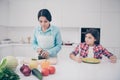 Portrait of two nice cute lovely attractive irritated annoyed bored tired girl demanding meal mature mom making lunch in Royalty Free Stock Photo