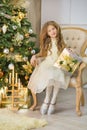 Portrait of two one young girls sisters close to white green Christmas tree. The girls in beautiful evening dresses clothes in New Royalty Free Stock Photo