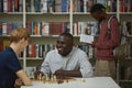 Two people playing chess in library Royalty Free Stock Photo