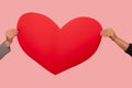 Portrait of two person hands holding big red paper heart, symbol of romantic love on Valentine`s day Royalty Free Stock Photo