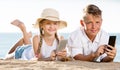 Smiling kids on beach with phone in hands Royalty Free Stock Photo